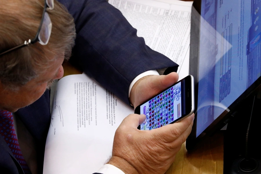 A Russian lawmaker plays a game on his mobile phone during a vote on the pension reform bill at the State Duma, the lower house of parliament, in Moscow Russia September 26, 2018. 