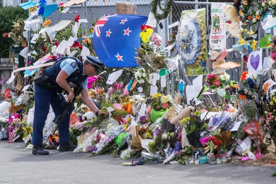 A police officer places flower at a memorial for the victims of the mosque shooting in Christchurch, New Zealand, March 22, 2019.