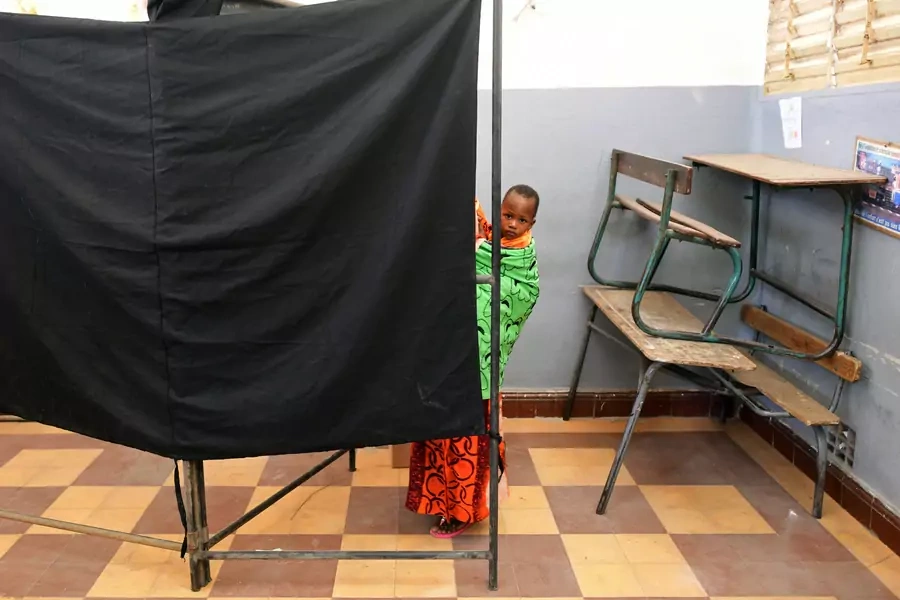 A woman carries a child as she casts her vote during presidential election, at a polling station in Medina neighborhood, in Dakar, Senegal, on February 24, 2019.