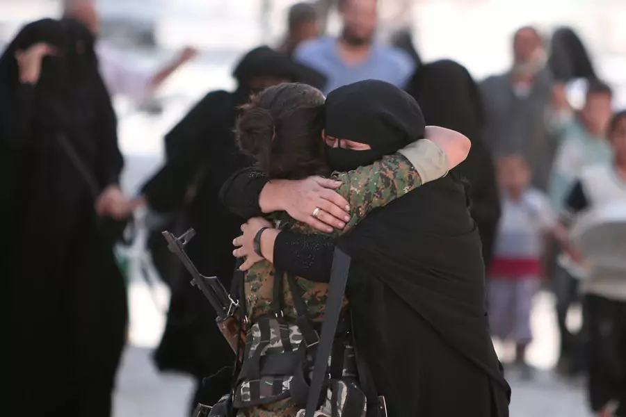 A woman embraces a Syria Democratic Forces (SDF) fighter after she was evacuated with others by the SDF from an Islamic State-controlled neighbourhood of Manbij, in Aleppo Governorate, Syria, August 12, 2016.