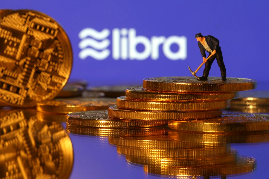 A small toy figure stands on representations of virtual currency in front of the Libra logo in this illustration picture, June 21, 2019.