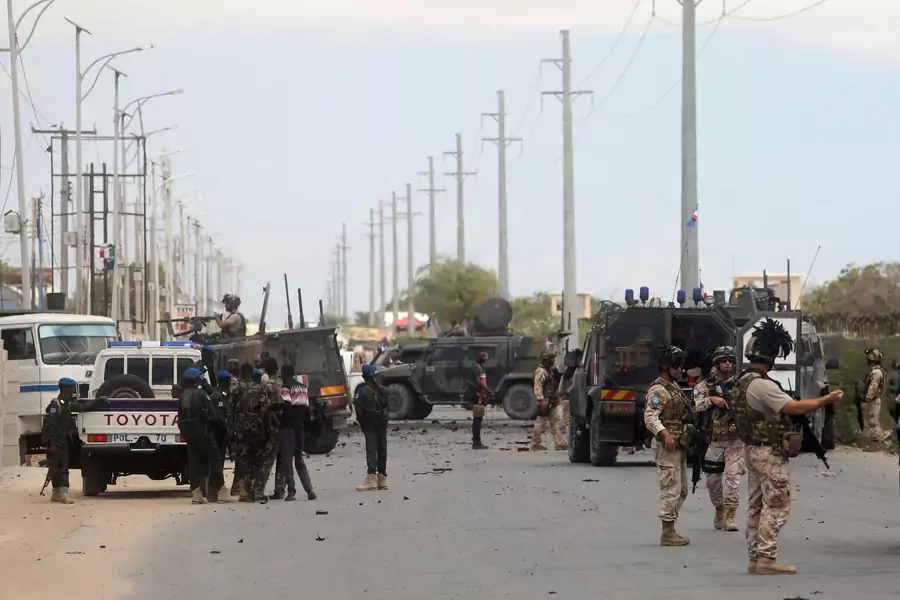 Italian and Somali security forces are seen near armored vehicles at the scene of an attack on an Italian military convoy in Mogadishu, Somalia September 30, 2019
