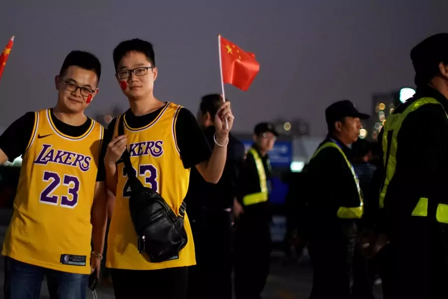 Fans in LeBron James jerseys pose for pictures with Chinese flags near security personnel outside the Mercedes-Benz Arena before the NBA exhibition game between Brooklyn Nets and Los Angeles Lakers in Shanghai, October 10, 2019.