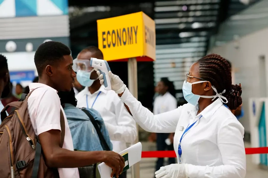A health worker checks the temperature of a traveller as part of the coronavirus screening procedure at the Kotoka International Airport in Accra, Ghana, on January 30, 2020. 