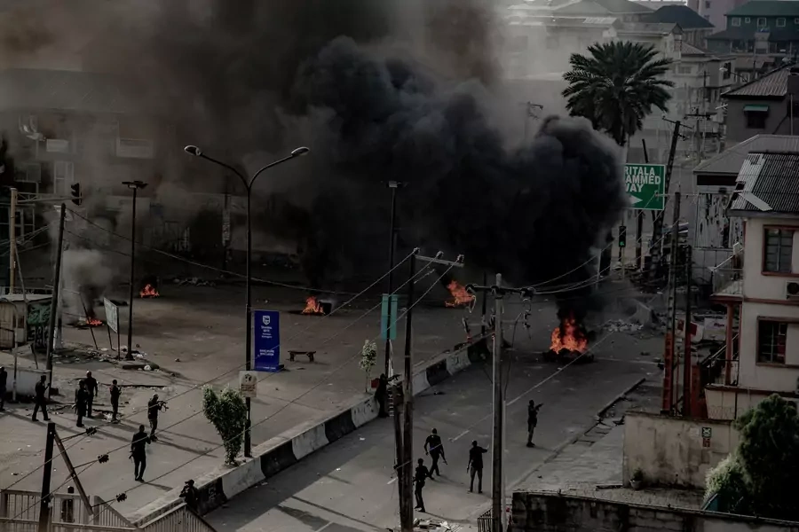 Armed men are seen near burning tires on the street, in Lagos, Nigeria on October 21, 2020.