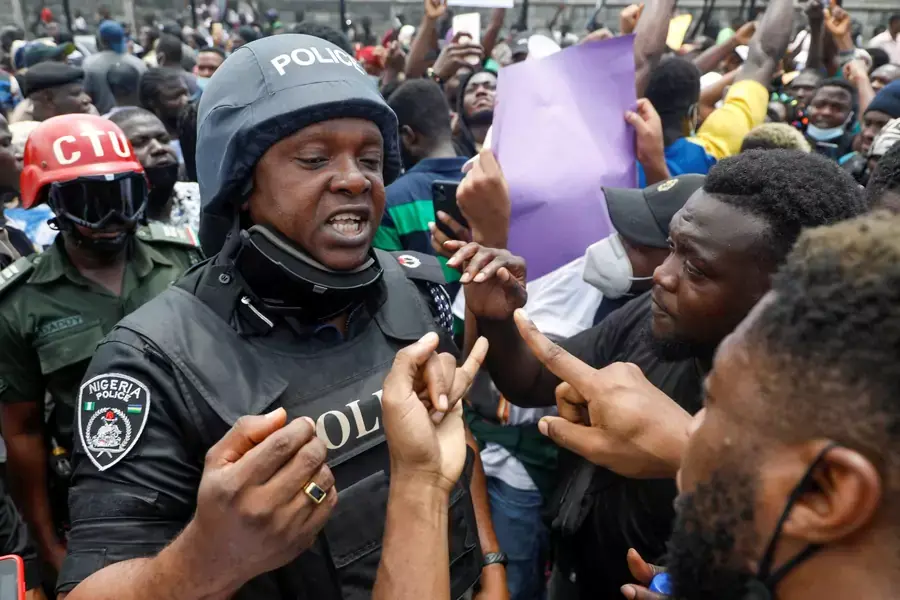 Demonstrators talk to a police officer during a protest over alleged police brutality, in Lagos, Nigeria on October 12, 2020.