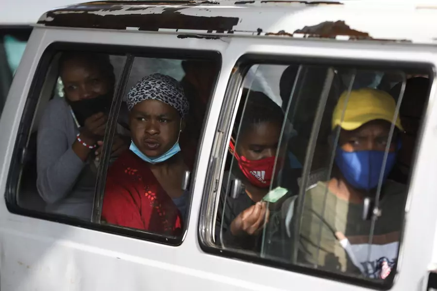 Commuters, some wearing face masks, look on through a window at the Baragwanath taxi rank, amid the coronavirus disease (COVID-19) outbreak, in Soweto, South Africa on December 29, 2020.
