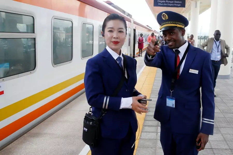 Kenya Railways attendants talk next to a train along the Standard Gauge Railway (SGR) line constructed by the China Road and Bridge Corporation (CRBC) and financed by the Chinese government in Ongata Rongai, Kenya, on October 16, 2019.