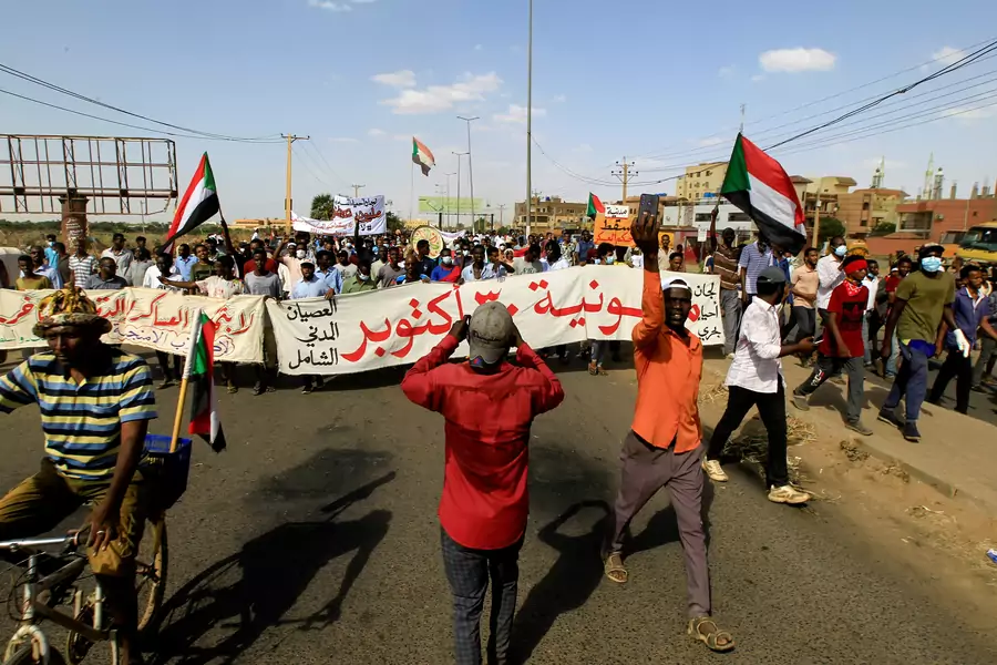 Protesters carry a banner and national flags as they march against the Sudanese military's recent seizure of power and ousting of the civilian government, in the streets of the capital Khartoum, Sudan on October 30, 2021.
