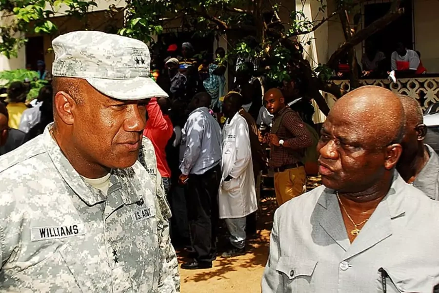 Maj. Gen Darryl A. Williams, former commander of Joint Forces Command-Operation United Assistance Assistance speaks with Liberian Minister of National Defense Hon. Brownie Samukai, during a tour of a rural village in Liberia on October 20, 2014.