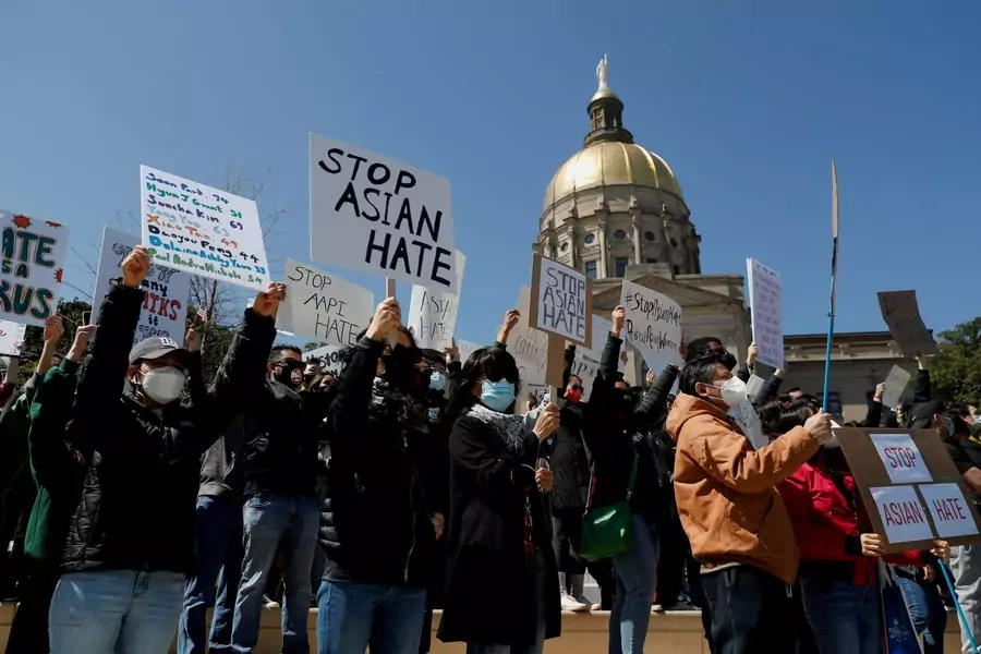 People hold placards during a "Stop Asian Hate" rally on March 20, 2021, following deadly shootings at a spa in Atlanta, Georgia.