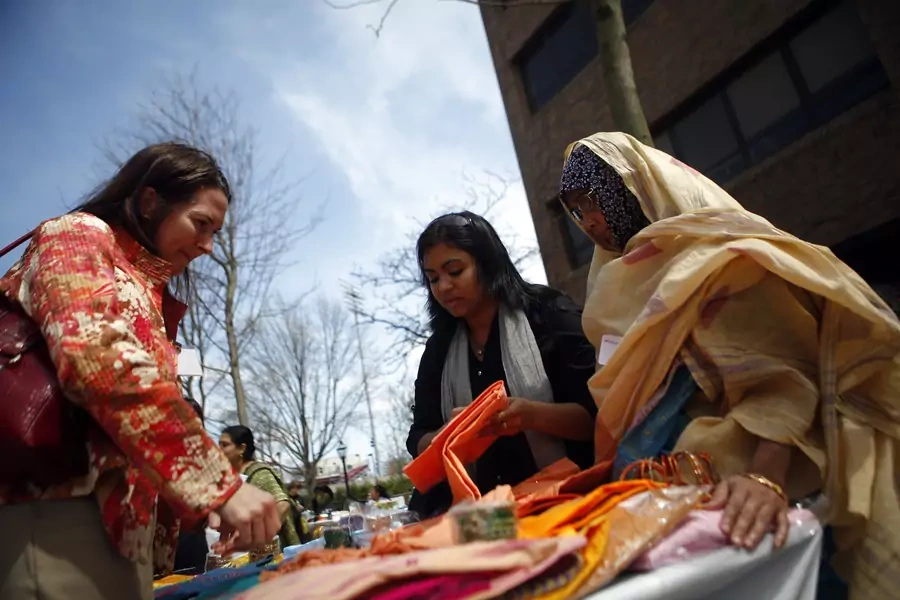Women sell items at a Grameen America open house at St. John's University in New York