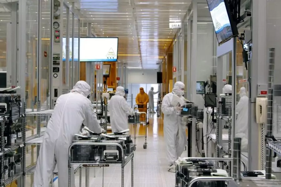 Workers move equipment inside the SkyWater Technology Inc. semiconductor plant in July 2022.