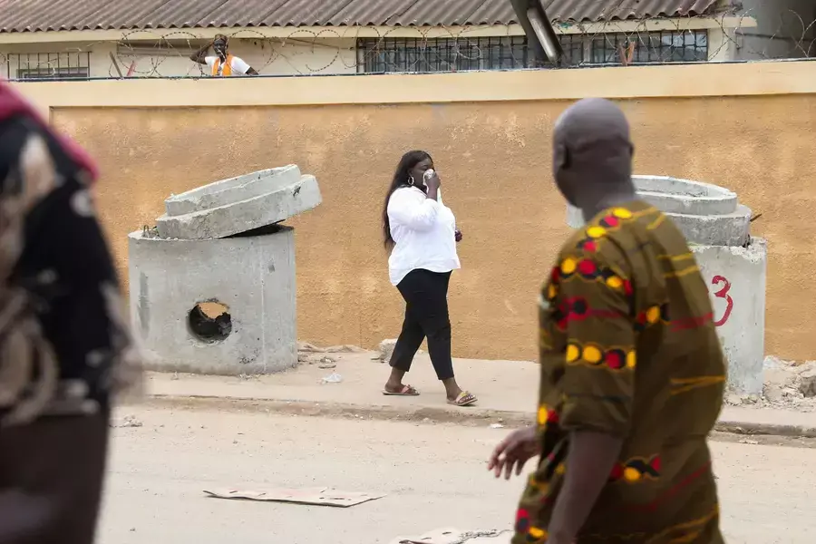 A woman covers her face after gendarmes shot tear gas to disperse a crowd of protestors after opposition leader Ousmane Sonko was detained, in Dakar, Senegal on July 31, 2023.