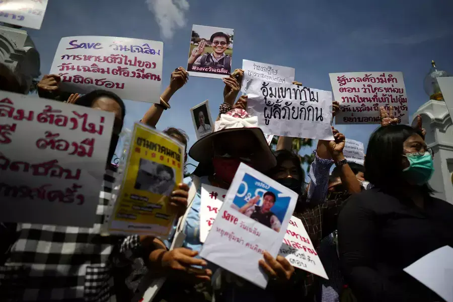 Activists hold up pictures of abducted Thai activist Wanchalearm Satsaksit as people gather in support of him during a protest calling for an investigation, in front of the Government house in Bangkok, Thailand, on June 12, 2020.