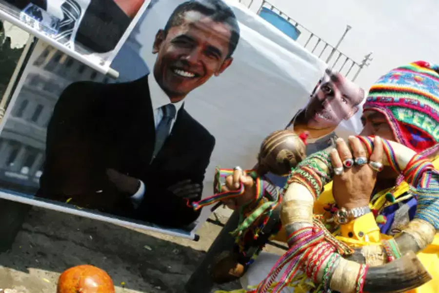 A shaman performs a ritual in front of a photograph of President Barack Obama in Lima 