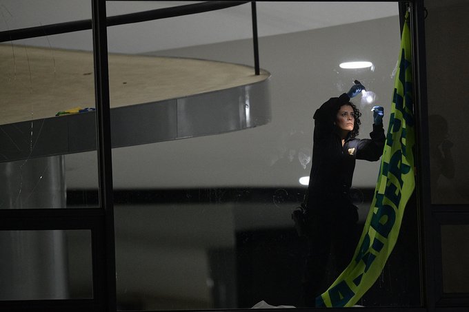 A member of the Federal Police forensics team inspects the damage caused at the Planalto palace