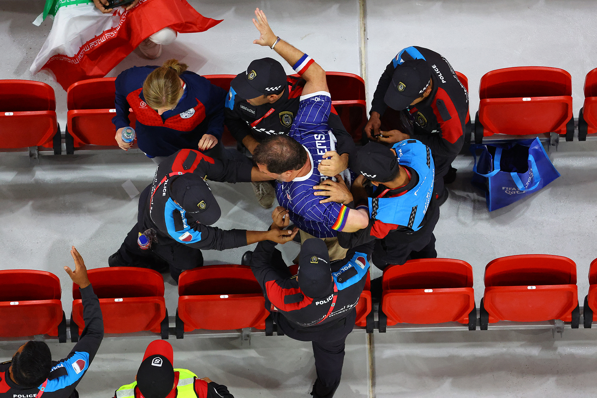  A fan wearing a rainbow coloured arm band is removed from the stands by police officers at a FIFA World Cup game on November 29, 2022