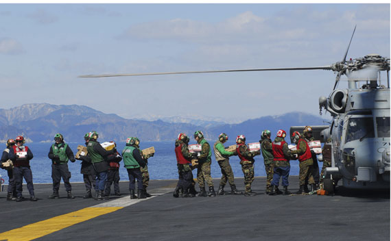 Sailors load food and humanitarian supplies onto a helicopter aboard the USS Ronald Reagan which is off the coast of Japan providing humanitarian assistance as directed in support of Operation Tomodachi, March 18, 2011.