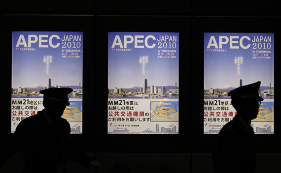 Policemen are silhouetted on signboards of APEC forum summit in Yokohama, south of Tokyo