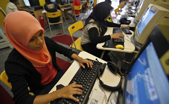 Mas Ayu Adnan, a student, checks her assignment at a cybercafe in Kuala Lumpur August 11, 2009.