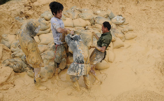 Labourers work at the site of a rare earth metals mine in Nancheng county, Jiangxi province October 20, 2010. China on Wednesday denied a report that the government plans to slash export quotas of rare earth metals next year, seeking to ease international jitters about China’s stranglehold on supplies. REUTERS/Stringer