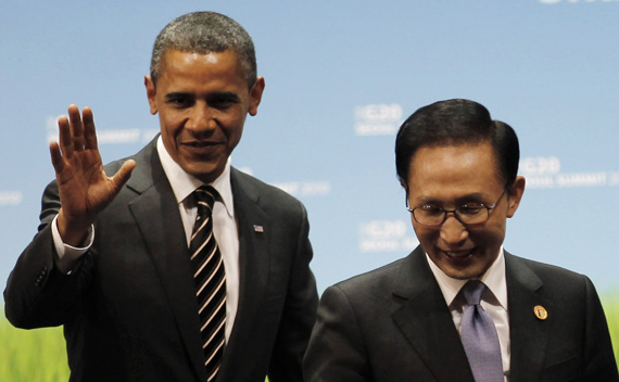 U.S. President Obama gestures next to South Korean President Lee on stage at the end of the G20 Summit in Seoul