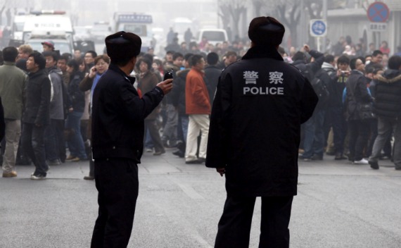 Policemen watch a crowd that gathered outside a McDonald’s restaurant after internet social networks called for a 