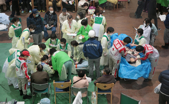 Survivors of an 8.9-magnitude earthquake and tsunami receive treatment at the Ishinomaki Red Cross hospital in Miyagi prefecture March 12, 2011. 