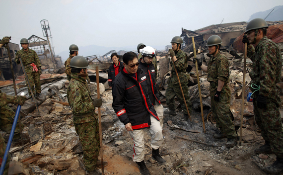 President of International Federation of Red Cross and Red Crescent Tadateru Konoe walks among rescue workers searching through rubble in residential area of tsunami-hit Otsuchi