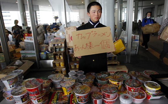 A student volunteer holds a sign in front of instant noodles for evacuees from Futaba, a city near the quake-stricken Fukushima Daiichi nuclear power plant, at the evacuees’ new shelter Saitama Super Arena, near Tokyo March 20, 2011, nine days after an earthquake and tsunami hit Japan. 