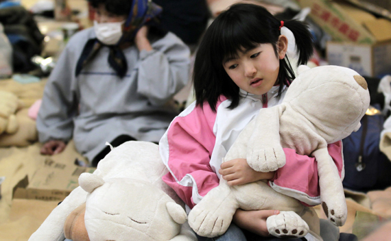 A girl holds her soft toy at an evacuation center in Koriyama, Fukushima Prefecture, northern Japan, March 31, 2011