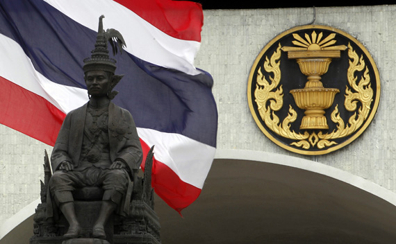 A Thai national flag flutters in the wind behind a statue of King Rama VII in front of the parliament building in Bangkok, May 10, 2011, ahead of a July 3 election.