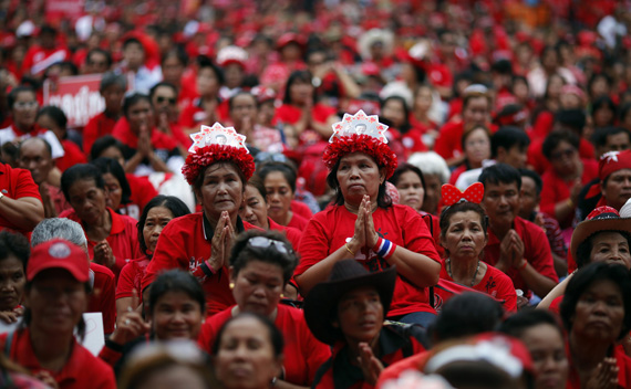 Anti-government ’’red shirt’’ protesters wear hats with pictures of toppled premier Thaksin Shinawatra as they pray during a rally at Ratchaprasong intersection at Bangkok’s shopping district May 19, 2011. Thousands of 