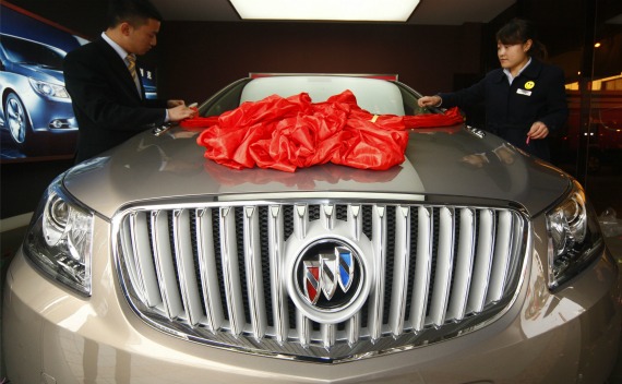 Employees decorate a Buick Regal car at a General Motors auto dealership in Suining, Sichuan province on November 18, 2010.