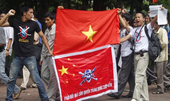 Anti-China protesters hold a Vietnamese flag (top) and a Chinese flag with an image of the pirate skull and crossbones (bottom) during a demonstration around Hoan Kiem lake in Hanoi July 24, 2011.