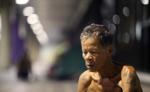 An elderly flood victim sits outside an evacuation centre at an unused airport terminal at Dan Mueang Airport in Bangkok October 24, 2011.