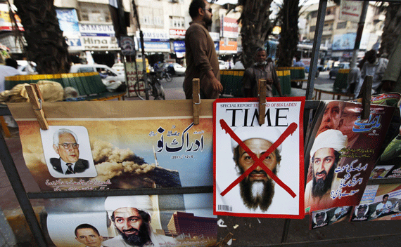 A newspaper stand displays magazines and posters bearing the pictures of al Qaeda leader bin Laden and U.S. President Obama in Karachi