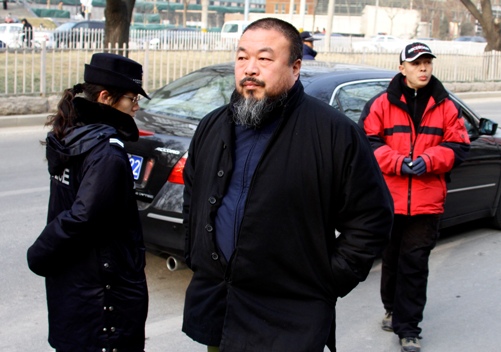 Chinese artist Ai WeiWei (C) walks past police as he arrives to give support to Liu Xiaobo, one of China’s most prominent dissidents, outside the courthouse where Liu is on trial in Beijing December 23, 2009. Liu went on trial on subversion charges on Wednesday, drawing an outcry at home and abroad over the country’s sweeping laws against political opponents. Chinese prosecutors accuse Liu of 