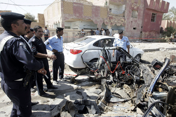 Policemen gather at the site of a bomb attack in Najaf, 160 km (100 miles) south of Baghdad August 15, 2011. At least three people were killed and 19 more wounded when two car bombs exploded, authorities said. Police captain Hadi al-Najafi in Najaf said the bombs targeted a police building. Suicide attackers and car bombs struck cities across Iraq on Monday, killing at least 50 people and wounding scores more in a rash of apparently coordinated assaults carried out by affiliates of al Qaeda, authorities said. REUTERS/Ali Abu Shish