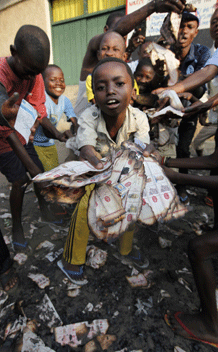 Children show burnt election ballots outside a polling station at Matete district in Kinshasa November 29, 2011. The African Union urged candidates in Democratic Republic of Congo’s elections on Wednesday to accept the outcome of this week’s polls, saying they were well managed despite technical problems and violence. REUTERS/Emmanuel Braun