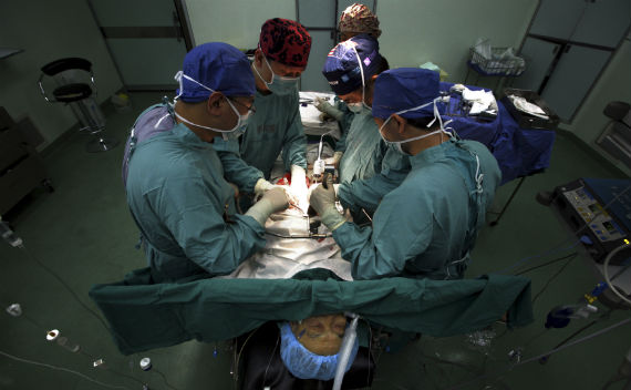 Doctor Ji Jiafu operates with his staff on a cancer patient in an operating theatre in the Beijing Cancer Hospital July 12, 2011. (David Gray/Courtesy Reuters)