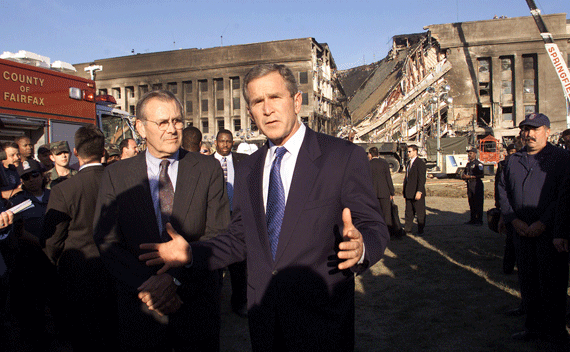 Accompanied by Secretary of Defense Donald Rumsfeld (L), President George W. Bush speaks in front of the west side of the Pentagon September 12, 2001 where terrorists plunged an airliner early Tuesday, September 11. REUTERS/Kevin Lamarque 