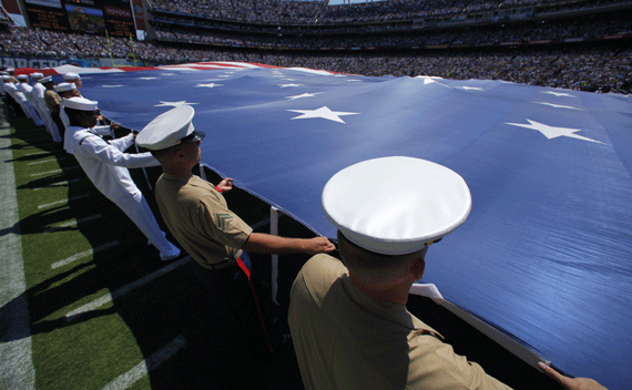 U.S. military personnel hold a huge American flag holding it over the football field during the national anthem prior to the San Diego Chargers season opening NFL football game in San Diego, California September 11, 2011. REUTERS/Mike Blake