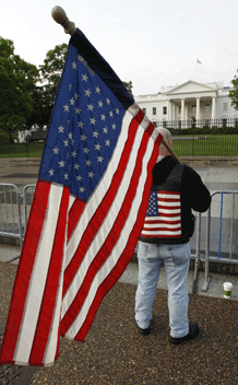 A man holds a flag outside the White House in Washington. (Kevin Lamarque/courtesy Reuters)