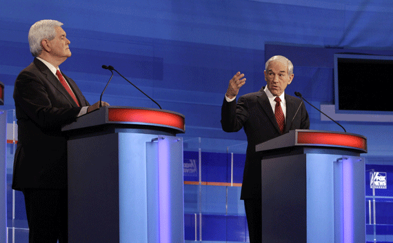 Republican presidential candidate, U.S. Representative Ron Paul (R-TX), makes a point as former U.S. Speaker of the House Newt Gingrich (R-GA) (L) listens during the Republican Party presidential candidates debate in Sioux City, Iowa, December 15, 2011. REUTERS/Jim Young (UNITED STATES - Tags: ELECTIONS POLITICS)