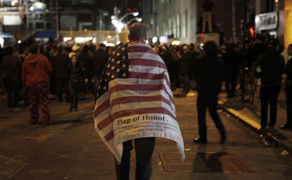 A man carries an American flag while walking to join a crowd gathered to celebrate the death of Osama bin Laden at the construction site at Ground Zero in New York on May 2, 2011.