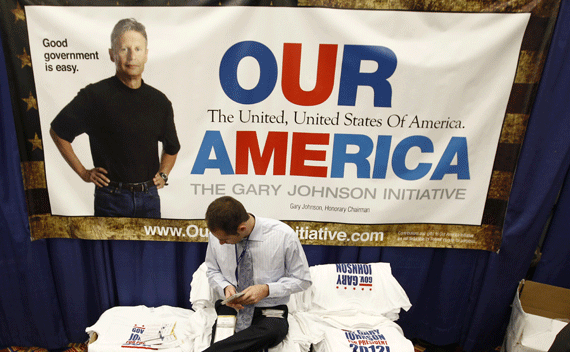 A worker sits on a pile of presidential campaign T-shirts for former New Mexico Governor Gary Johnson at the Conservative Political Action conference in Washington February 10, 2011. (Kevin Lamarque/courtesy Reuters)