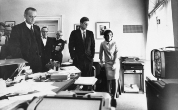 President John F. Kennedy, First Lady Jacqueline Kennedy, McGeorge Bundy, and other advisors gather around a television.