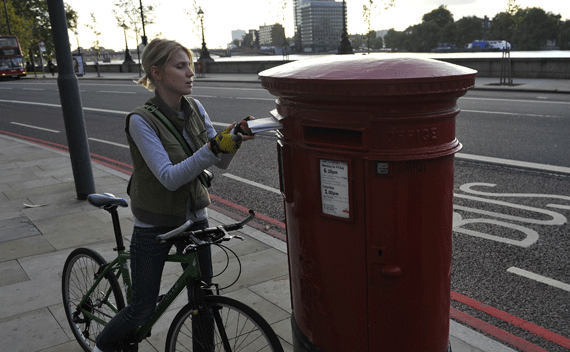 A cyclist posts a parcel in Royal Mail postbox on the Embankment in London October 8, 2009. Workers at Britain’s state-owned Royal Mail voted overwhelmingly for a nationwide strike on Thursday, escalating a dispute over pay and conditions which has caused widespread disruption to postal services. REUTERS/Kieran Doherty